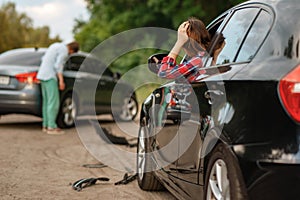 Male and female drivers after car accident on road