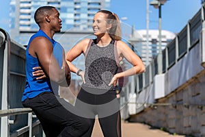 Male and female fitness partners relaxing and enjoying a laugh, smiling, happy and healthy lifestyle portrait, exercising in the c