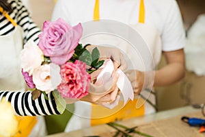 Male and female florists with beautiful bouquets in flower shop.