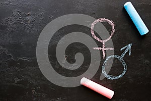 Male and female gender symbols on a black background with space for text