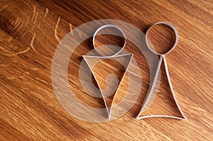 Male and female gender symbols on wooden background.