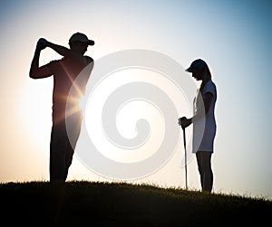 Male and female golfers playing golf
