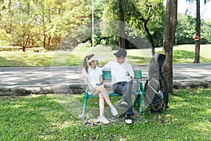 Male female golfers talking and plan for play golf in the lawn, sitting relax on chair in the garden. Sport hobby concept