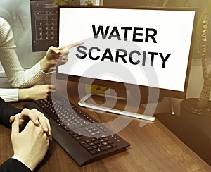 Male and female hand, computer with text Water scarcity with office background