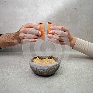 Male and female hands holding persimmon under plate with persimmon dessert