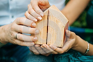 The male and female hands holding a small house