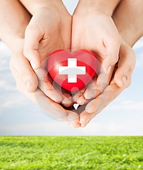 Male and female hands with red heart