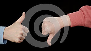 Male and female hands showing thumbs up and down