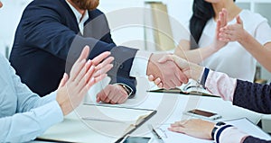 Male and female handshake in office. Businessman in suit shaking woman`s hand in the meeting room.