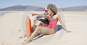 Male and female lifeguards sitting on beach