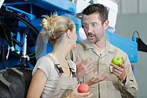 male and female manual worker eating apple for lunch