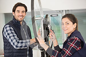 male and female mechanics working on bicycle