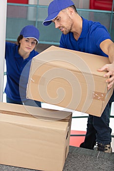 male and female movers carrying boxes