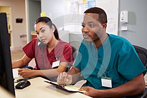 Male And Female Nurse Working At Nurses Station