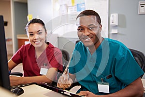 Male And Female Nurse Working At Nurses Station