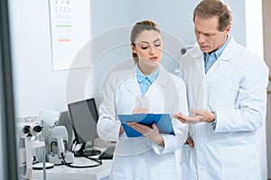 male and female optometrists writing diagnosis