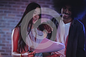 Male and female performers reading papers in nightclub