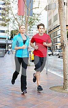 Male And Female Runners On Urban Street