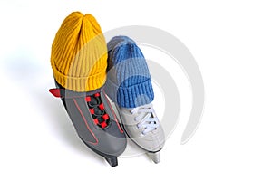 Male and female skates in knitted blue and yellow winter hats isolated on white background