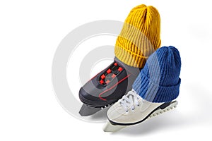 Male and female skates in knitted blue and yellow winter hats  on white background