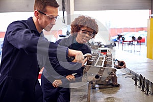 Male And Female Students Work On Car Engine Block On Auto Mechanic Apprenticeship Course At College