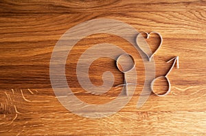 Male and female symbols with heart and copy space on wooden background.