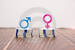 Male and female symbols on piles of coins