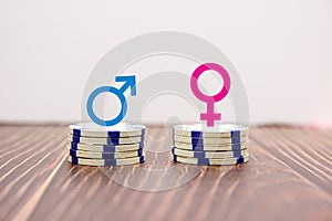 Male and female symbols on piles of coins photo