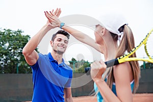 Male and female tennis players gives five