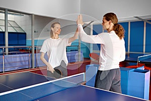 Male and female tennis players giving high-five to each other