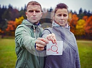 Male and female together holding piece paper with drawing transgender symbol. Human sex rights. Gender symbol