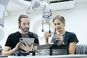 Male and female using tablet staff engineer with robot for education at class room. Education for future robotics learning