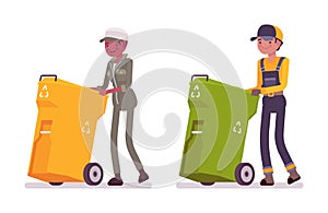 Male and female waste collectors in uniform pushing trash bins