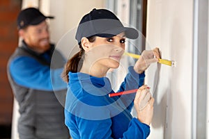 male and female worker measure wall photo