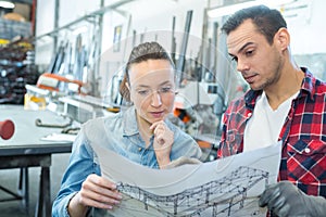 male and female workers looking at blueprint