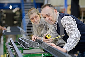 Male and female workers in metalworks factory