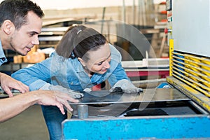 male and female workers in metalworks factory