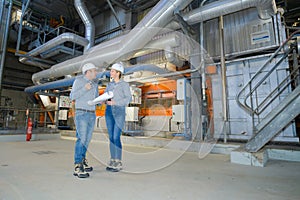 male and female workers talking in industrial manufacturing plant