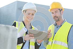 male and female workes discussing over tablet in shipping yard