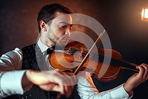 Male fiddler playing classical music on violin