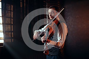 Male fiddler playing classical music on violin