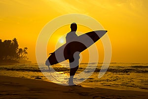 The male figure with a board for surf on a background of ocean w