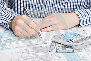 Male filling out 1040 US Tax Form - studio shot