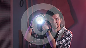 Male filmmaker adjusting professional light stand in studio, with lighting on