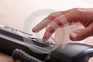 Male finger dialing a telephone number