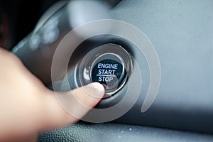 Male finger pressing engine start stop button