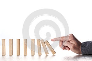 Male finger pushing domino blocks with falling chain reaction isolate on white background with copy space for your text