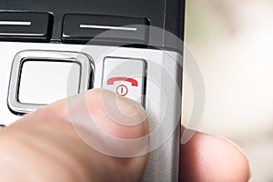 Male Finger On The Red Hang Up Button Of A Wireless DECT Telefphone, Ready To End The Call