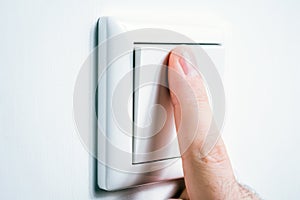 Male Finger Touching A Light Switch To Turn The Light On Or Off