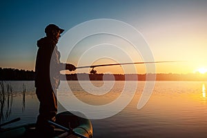 Male fisherman at dawn on the lake catches a fishing rod. Fishing hobby vacation concept. Copy space